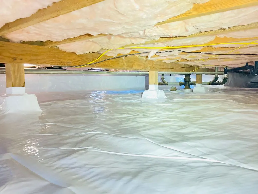 Crawl space sealed with a reinforced vapor barrier.