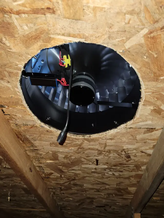 Solar fan housing installed through the roof deck, seen from the attic