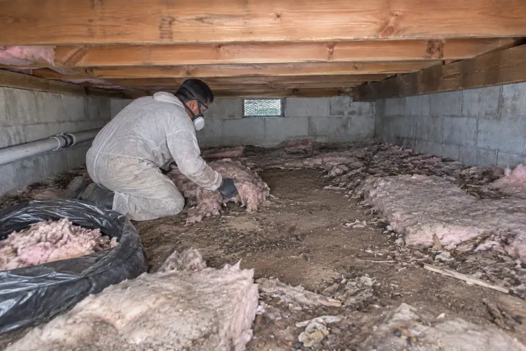 Block-wall crawl space cleanout, in progress: Bagging old insulation for removal.