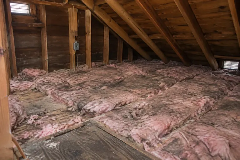 Pink batts replaced with blown-in insulation, before: Thin, dirty batts that no longer cover the joists.