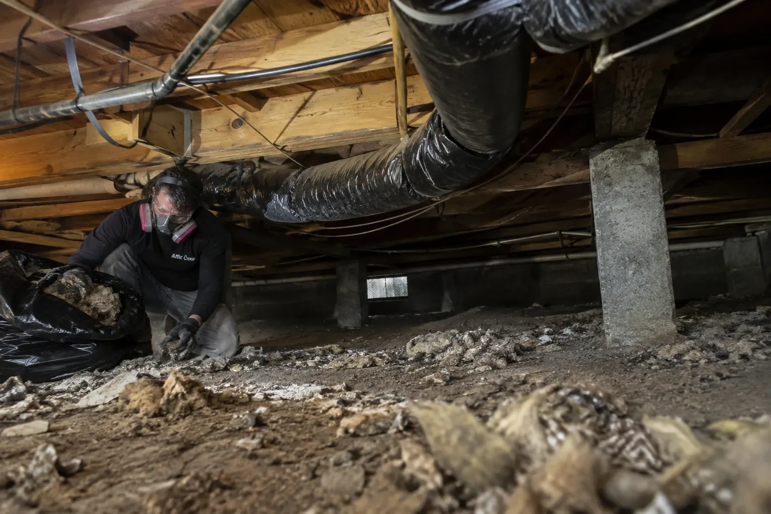 Removing debris and old insulation from under the floor.