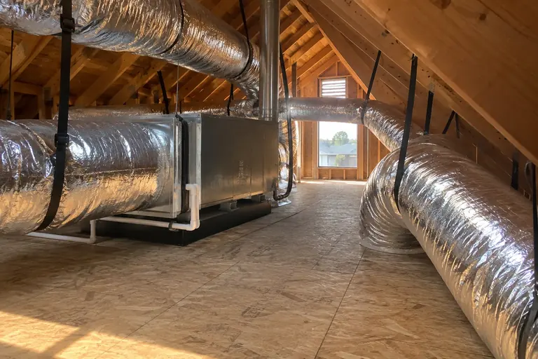 A new air handler and insulated duct system installed in an attic.
